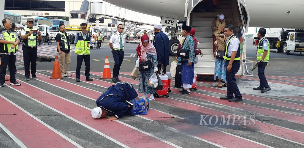 Salah satu anggota jemaah haji debarkasi Surabaya langsung bersujud syukur setibanya kembali di Bandara Juanda Surabaya, Selasa (4/7/2023). Ada tiga kelompok terbang yang membawa kepulangan jemaah haji pada hari pertama. 