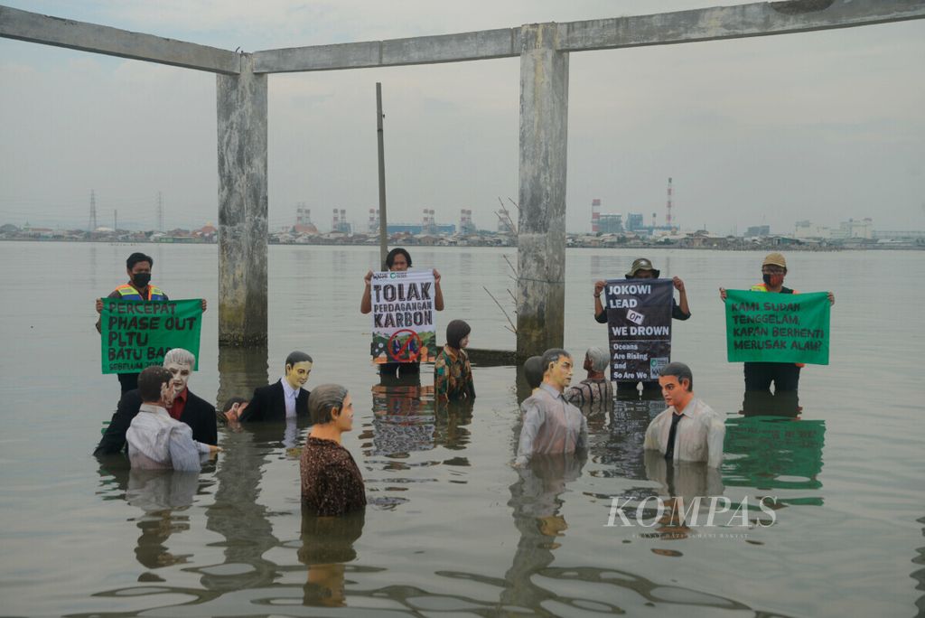 Aktivis Wahana Lingkungan Hidup Indonesia (Walhi) Jawa Tengah membentangkan poster kritik kepada pemerintah tentang persoalan lingkungan di Kota Semarang, Jawa Tengah, Jumat (5/11/2021).