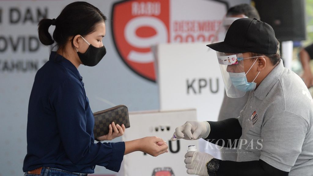 Petugas memberikan tinta kepada warga yang telah memberikan hak suaranya dalam kegiatan simulasi pemungutan suara pilkada serentak 2020 di Cilenggang, Serpong, Tangerang Selatan, pada Sabtu (12/9/2020). 