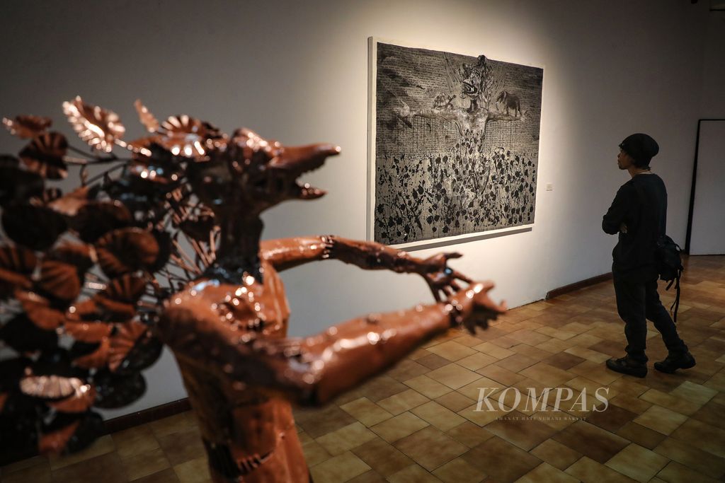 Seorang pengunjung mengamati karya Putu Sutawijaya dalam pameran ”Lelampah” di Bentara Budaya Jakarta, Kamis (14/9/2023). Mengangkat tema ”Garuda”, Putu Sutawijaya menampilkan 10 lukisan, 23 lukisan yang diolah dari foto, video dokumentasi riset, serta sejumlah instalasi dan patung. Pameran tersebut berlangsung pada 14-29 September 2023. 