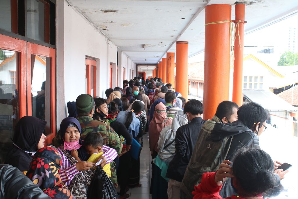 Puluhan warga mengantre untuk mengambil bantuan sosial dari Pemerintah Provinsi Jawa Barat di Kantor Pos Jalan Asia Afrika, Kota Bandung, Selasa (29/12/2020). Sebagian warga tidak menerapkan protokol kesehatan seperti berkerumun dan tidak menggunakan masker dengan benar.