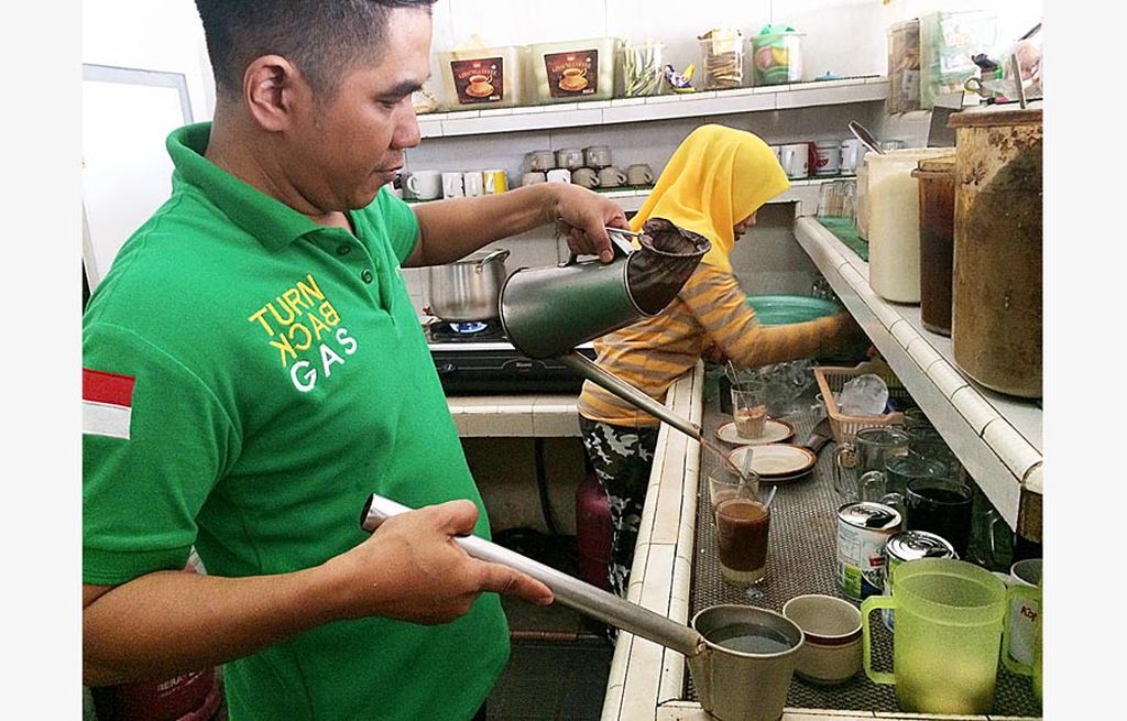 Penyiapan kopi susu di Warung Kopi Ahok, Kota Jambi.