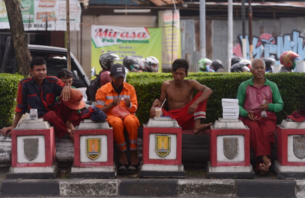 Pekerja melepas lelah setelah membersihkan taman di Kota Semarang, Jawa Tengah, Kamis (16/4/2020). Penutupan berbagai jenis tempat usdaha karena pandemi Covid-19 dalam beberapa bulan ini menambah jumlah pengangguran dan pemecatan karena industri yang lesu.