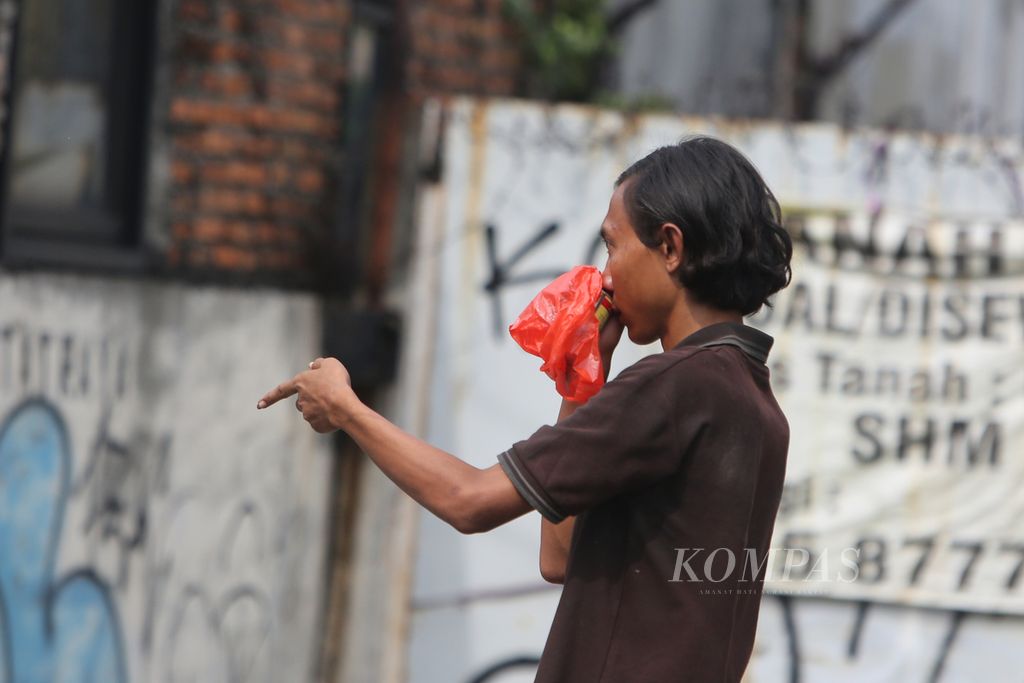Anak jalanan menghirup lem untuk mendapatkan efek ”melayang” di kawasan Kebayoran Lama, Jakarta Selatan, Kamis (23/6/2022). Penyalahgunaan lem yang tidak sesuai dengan fungsinya ini dapat berdampak negatif bagi kesehatan penggunanya.