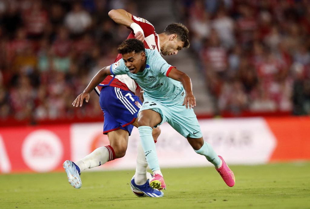 Penyerang Barcelona, Lamine Yamal, mencoba melewati pemain Granada, Lucas Boye, pada laga Liga Spanyol di Stadion Los Carmanes, Granada, Minggu (8/10/2023). Yamal digadang-gadang sebagai penerus Lionel Messi.