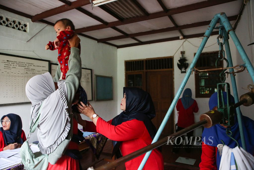 Kader posyandu membantu seorang ibu untuk menimbang anak balitanya di Posyandu Kemuning di Larangan, Kota Tangerang, Banten, Senin (13/2/2023). Posyandu menjadi garda terdepan pelayanan kesehatan bayi dan anak balita di Indonesia, termasuk upaya penanggulangan tengkes (stunting).