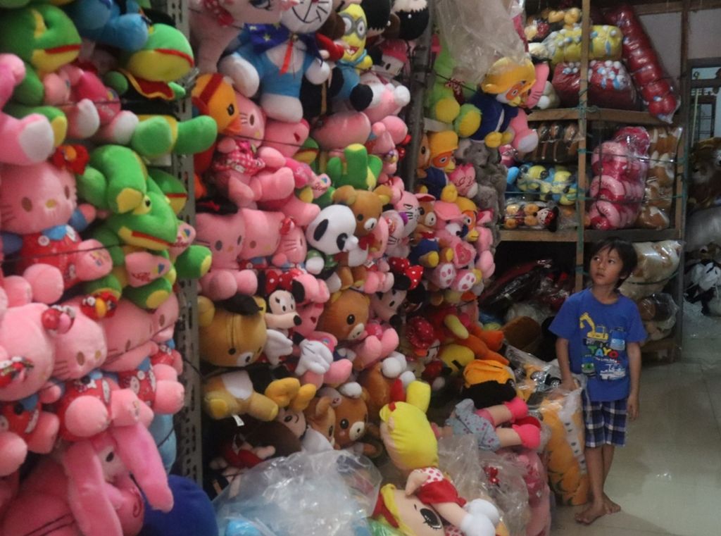 Seorang anak melihat-lihat boneka di etalase toko boneka di Kampung Baru Timur, Desa Cikampek Utara, Kecamatan Kotabaru, Karawang, Jawa Barat, Selasa (26/11/2019). Boneka dijual mulai harga Rp 10.000-Rp 350.000.