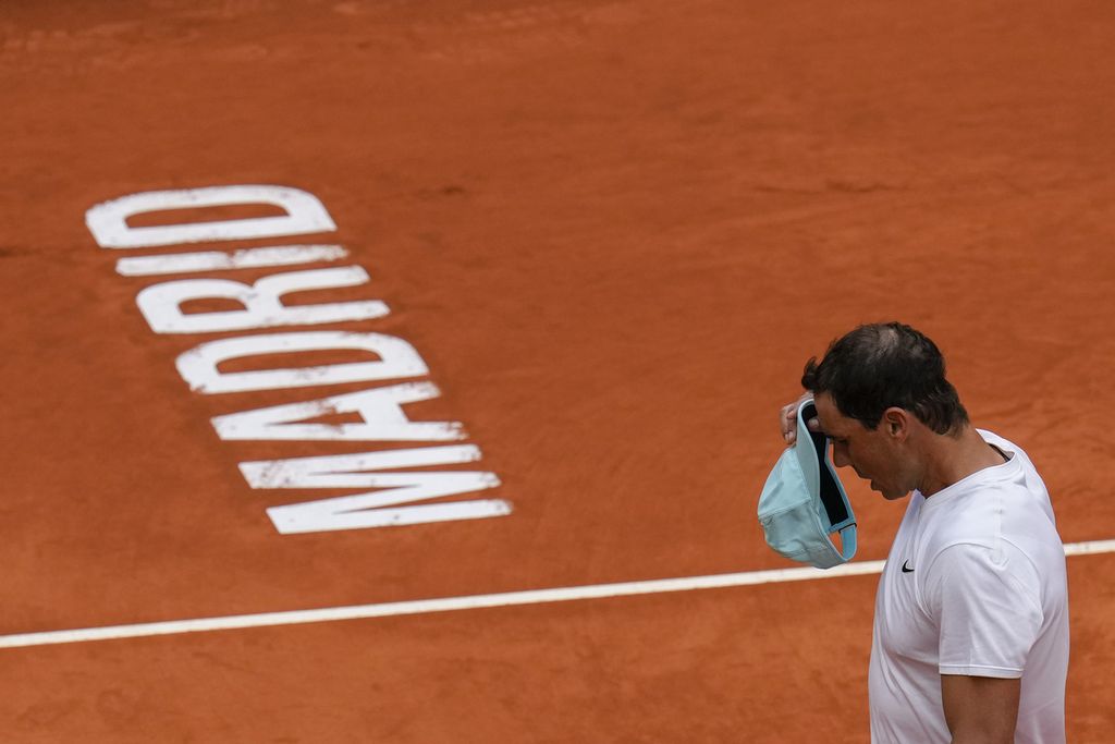 Petenis Spanyol, Rafael Nadal, memakai topinya di tengah sesi latihan di Caja Magica, Madrid, 28 April 2022, dalam persiapan untuk berlaga pada ATP 1000 Madrid Masters. Setelah 1,5 bulan absen karena cedera tulang rusuk, Nadal akan berlaga di babak kedua, Rabu (4/5/2022) malam WIB.