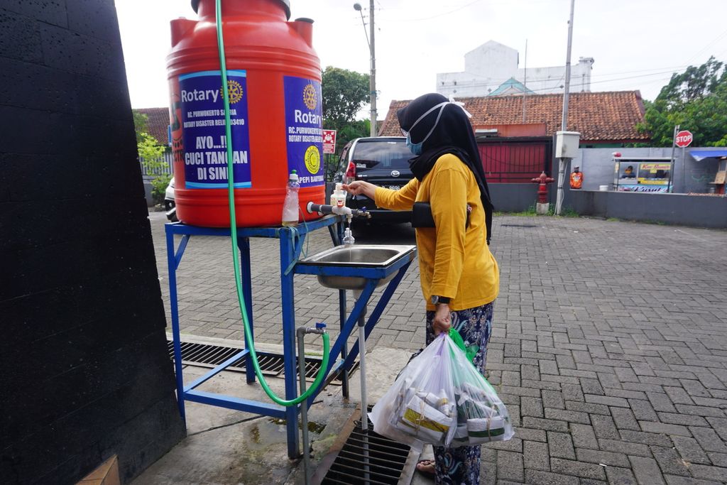 Pembeli mencuci tangan seusai berbelanja di Pasar Manis, Purwokerto, Banyumas, Jawa Tengah, Selasa (9/6/2020).