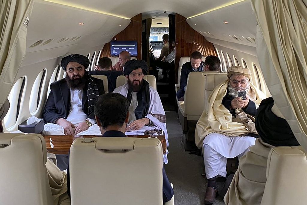 Menteri Luar Negeri Afghanistan Amir Khan Muttaqi (kiri), juru bicara Taliban untuk Kementerian Luar Negeri Abdul Qahar Balkhi (tengah), dan anggota delegasi Taliban berada di dalam pesawat yang membawa mereka menuju Oslo, Norwegia, Sabtu (22/1/2022). 