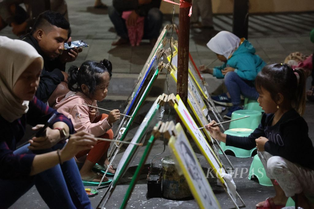 Anak-anak melukis saat menghadiri kegiatan Borobudur Car Free Night di depan pagar kompleks Taman Wisata Candi Borobudur, Kecamatan Borobudur, Kabupaten Magelang, Jawa Tengah, Sabtu (15/10/2022) malam. 