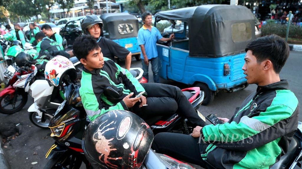 Sejumlah pengemudi ojek daring menunggu penumpang di sekitar Stasiun Pasar Senen, Jakarta Pusat, Selasa (19/6/2018). Layanan transportasi daring diperkirakan menjadi salah satu penarik minat warga untuk mengadu nasib di Jakarta.
