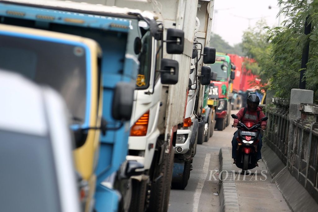 Pengendara sepeda motor berjalan di atas trotoar untuk menghindari kemacetan di Jalan Akses Marunda, Marunda, Jakarta Utara, Kamis (9/5/2024). 