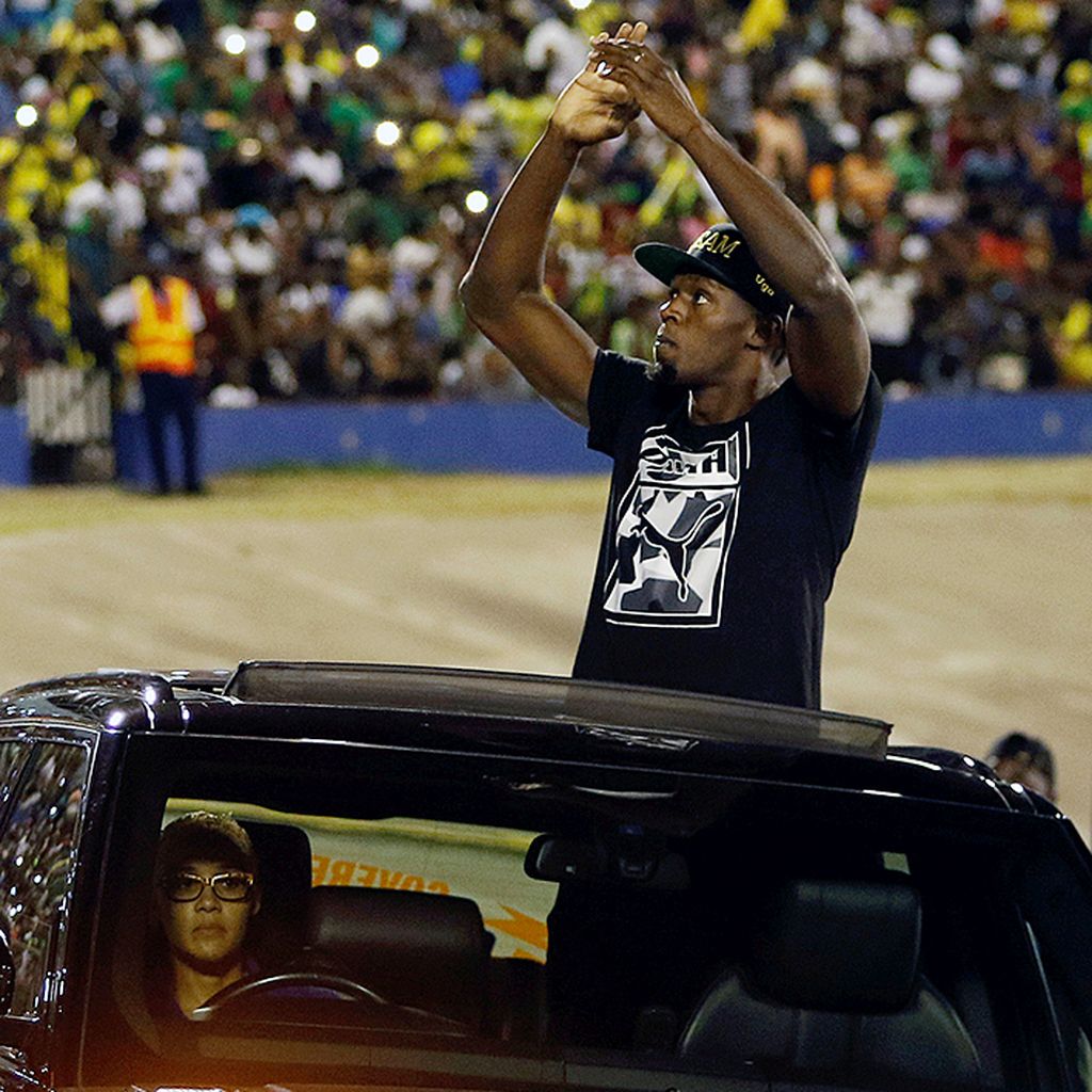 Sprinter Jamaika,  Usain Bolt, menyalami penggemarnya saat memutari Stadion Nasional Jamaika sebelum penampilan terakhirnya di Kejuaraan Atletik Jamaika di Stadion Nasional Jamaika, Kingston, Sabtu (10/6).  