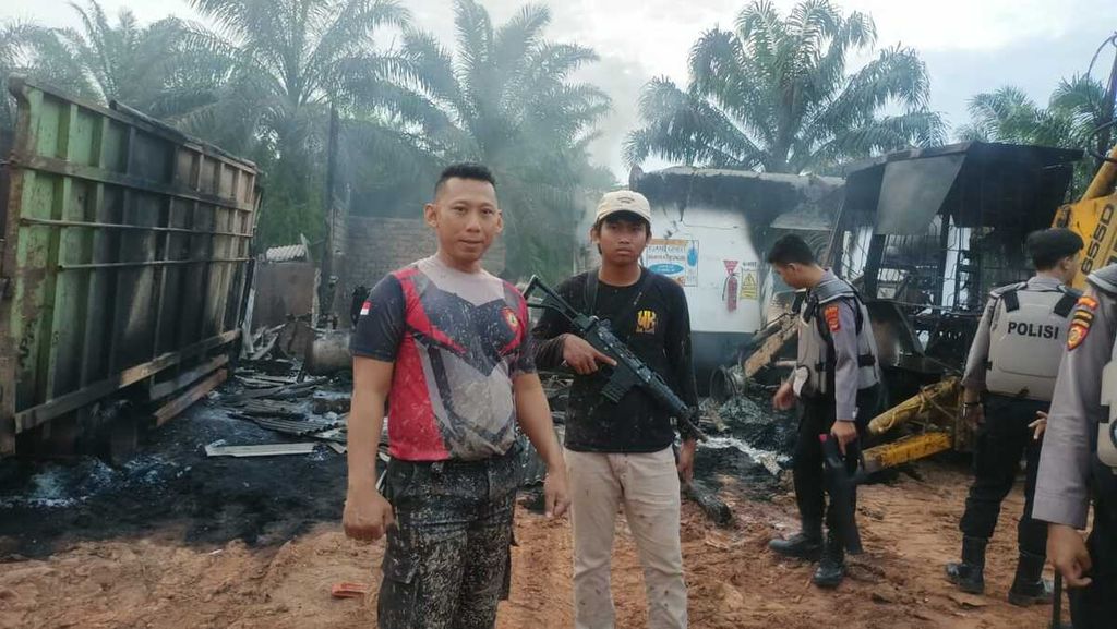 Polisi berjaga di dekat pabrik sawit yang dibakar sekelompok massa di Kabupaten Way Kanan, Lampung, Senin (30/1/2023). Pembakaran dipicu kemarahan warga sekitar setelah seorang warga tewas ditembak polisi karena diduga mencuri sawit. 