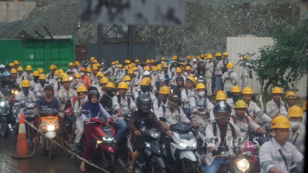 Pekerja pabrik pengolahan tambang milik di PT Indonesia Morowali Industrial Park (IMIP), Bahodopi, Kabupaten Morowali, Sulawesi Tengah, meninggalkan kawasan seusai kerja, 28 Januari 2019. 