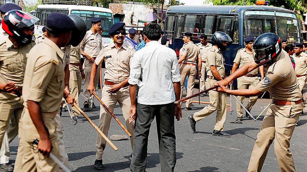 Polisi  India memukuli seorang warga Dalit  yang turut dalam unjuk rasa di  Ahmadabad, India, Senin (2/4/2018). Kekerasan  meletus di  India menyusul unjuk rasa itu. Warga Dalit  memprotes putusan Mahkamah Agung   yang  melemahkan perlindungan hukum  untuk komunitas terpinggirkan. 