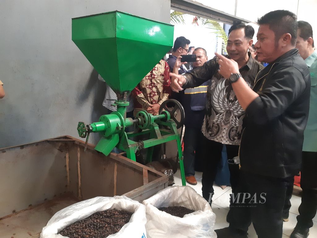 Gubernur Sumatera Selatan Herman Deru (kanan) melihat pemrosesan kopi di Pabrik Gending Sriwijaya yang terletak di Kabupaten Banyuasin, Sumsel, Kamis (30/3/2023). Pabrik ini dibuka sebagai alternatif bagi petani untuk menjual hasil perkebunannya, termasuk memperkuat identitas kopi Sumsel.
