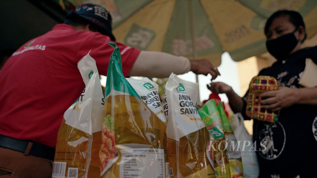 Residents pay for cooking oil at a cheap market in Bidara Cina Village, Jatinegara, East Jakarta, Friday (7/1/2022). In January 2022, as many as 20 cheap markets were held at a number of locations in DKI Jakarta by Food Station as a Regional Government Owned Food Company for the DKI Jakarta Provincial Government to maintain stock and stabilize food prices.