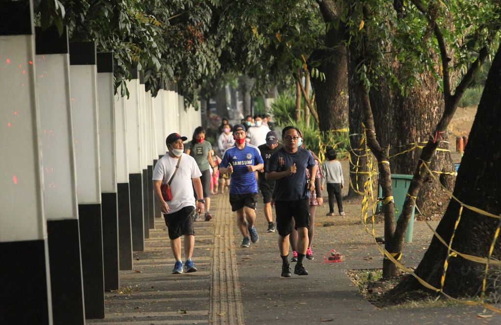 Warga berolahraga di trotoar di samping Lapangan Saparua, Kota Bandung, Jawa Barat, awal September 2021.
