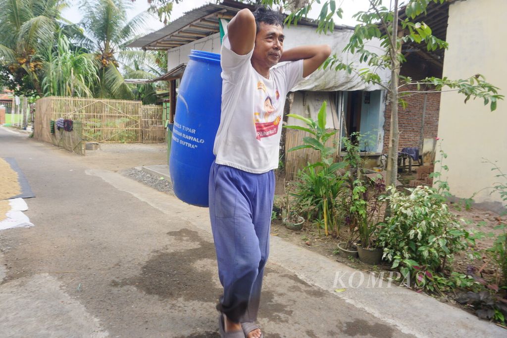 Warga menggotong tong untuk pengisian air bersih dari tim BPBD Banyumas serta jajaran Brimob Polda Jateng di Desa Tipar, Banyumas, Jawa Tengah, Jumat (4/8/2023).