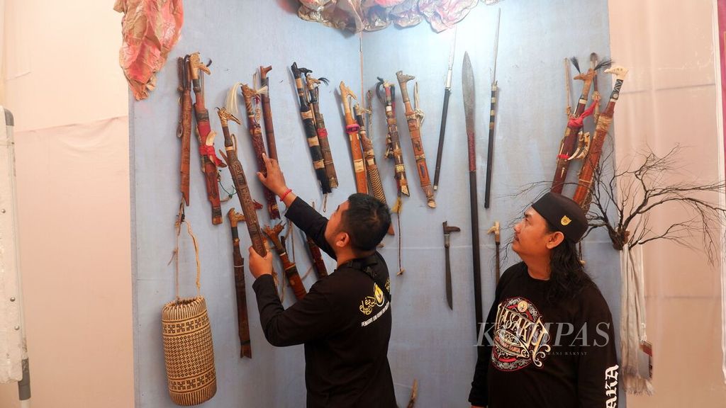 Penjaga stan memperlihatkan berbagai macam mandau, senjata etnik Dayak Kalimantan, yang dipajang dalam kegiatan Pameran Temporer di Museum Wasaka, Banjarmasin, Kalimantan Selatan, Jumat (14/10/2022). 