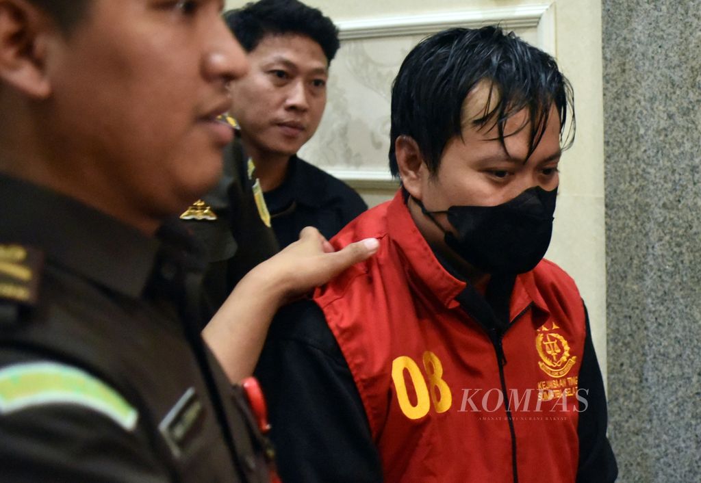 Salah seorang dari tiga tersangka dugaan kasus korupsi pajak di Palembang, Sumatera Selatan, digiring petugas Kejaksaan Tinggi Sumsel dari ruang pemeriksaan menuju mobil tahanan, Senin (6/11/2023) malam. 