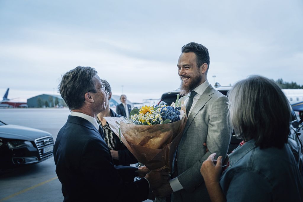 Johan Floderus (tengah), warga Swedia yang baru dibebaskan Pemerintah Iran, berbicara dengan Perdana Menteri Swedia Ulf Kristersson (kiri) yang menjemputnya di Bandar Udara Arlanda, Swedia, Sabtu (15/6/2024). 