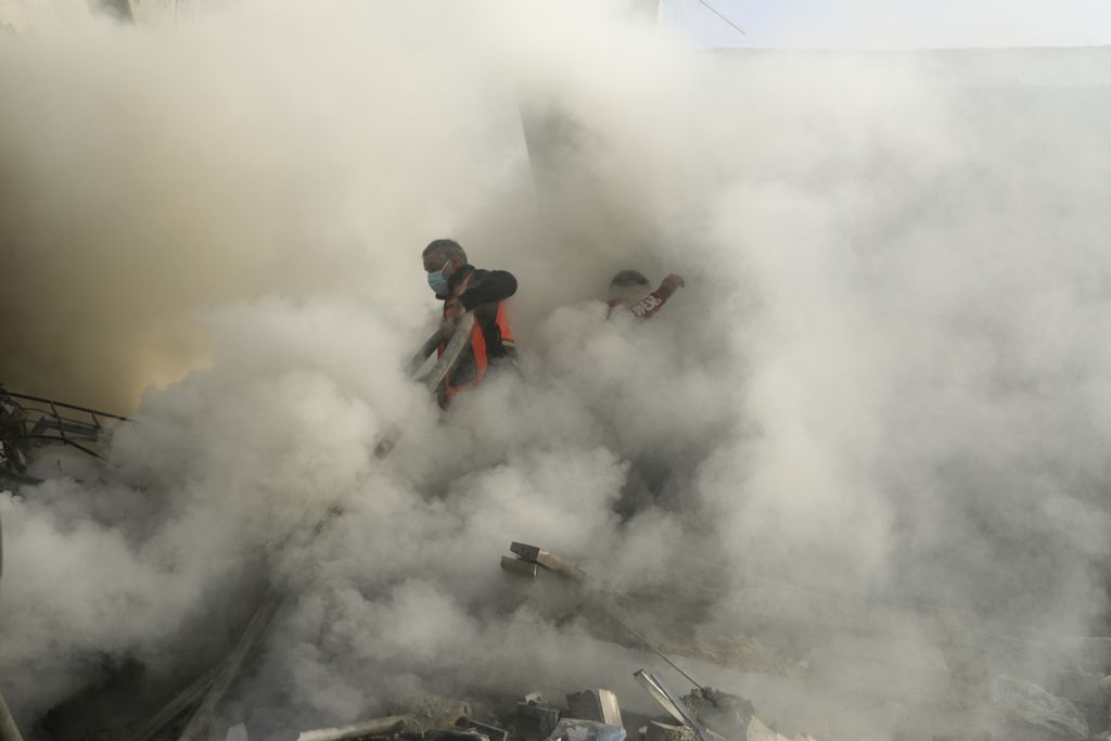Petugas pemadam kebakaran Palestina mencoba memadamkan api seusai serangan udara Israel ke kamp pengungsi Khan Younis di Gaza selatan, Selasa (7/11/2023). Meski dinyatakan sebagai tempat berlindung, wilayah Gaza selatan masih terus dibombardir militer Israel.