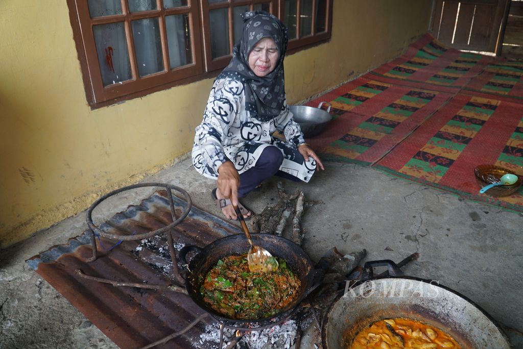 Jusdahniar (57) memasak rendang daun di rumahnya di Nagari Batu Bulek, Kecamatan Lintau Buo Utara, Tanah Datar, Sumatera Barat, Sabtu (28/5/2022). Rendang khas Lintau ini menggunakan bahan-bahan 50-an hingga 100-an jenis dedaunan dan belut sawah.