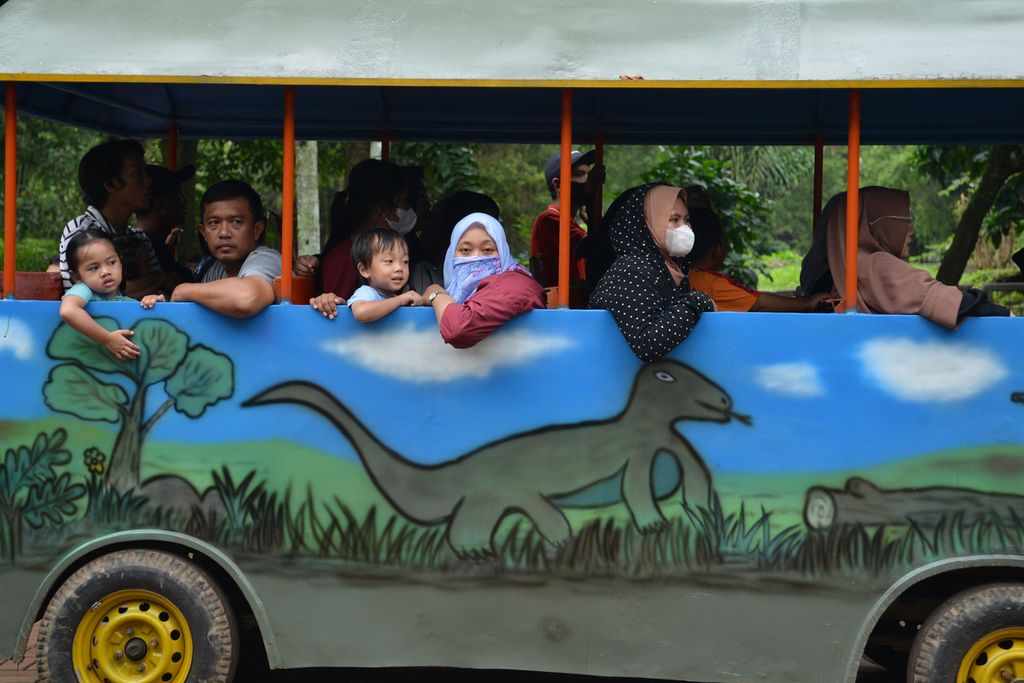 Warga menaiki kereta keliling saat berlibur di Kebun Binatang Ragunan, Jakarta Selatan, Minggu (25/12/2022). 