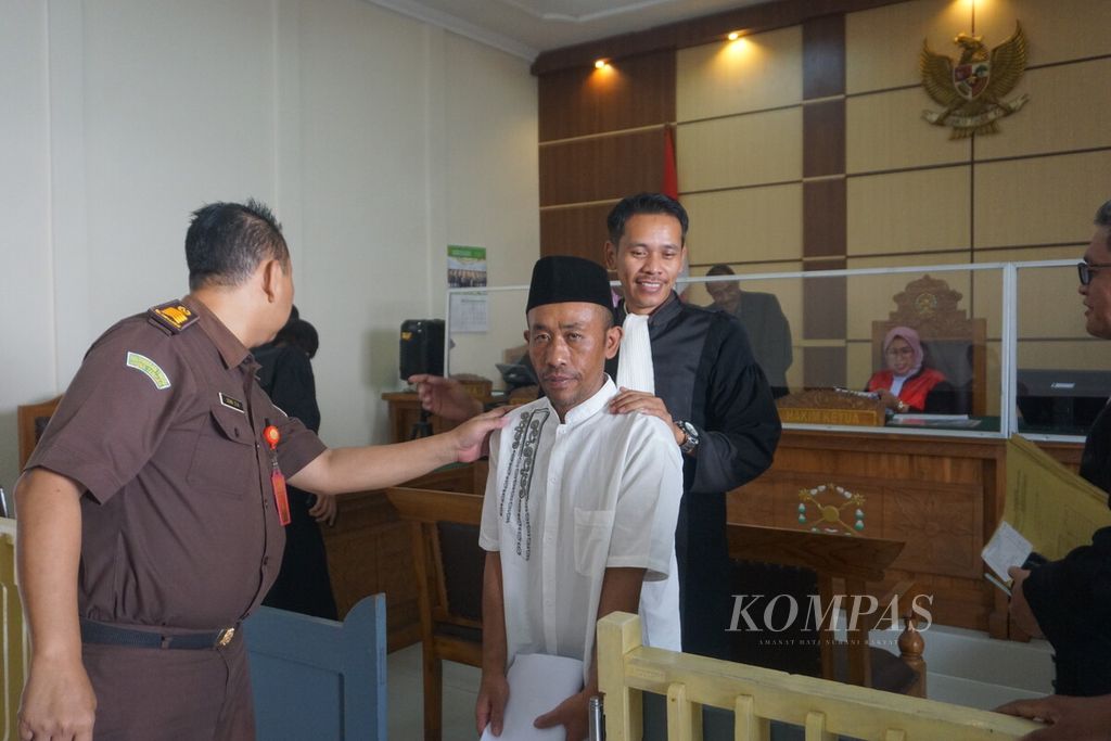Terdakwa Slamet Tohari (46) dikawal seusai mengikuti sidang perdana di Pengadilan Negeri Banjarnegara, Selasa (26/9/2023). Slamet didakwa kombinasi, mulai dari pembunuhan berencana, uang palsu, penipuan, hingga penggelapan.