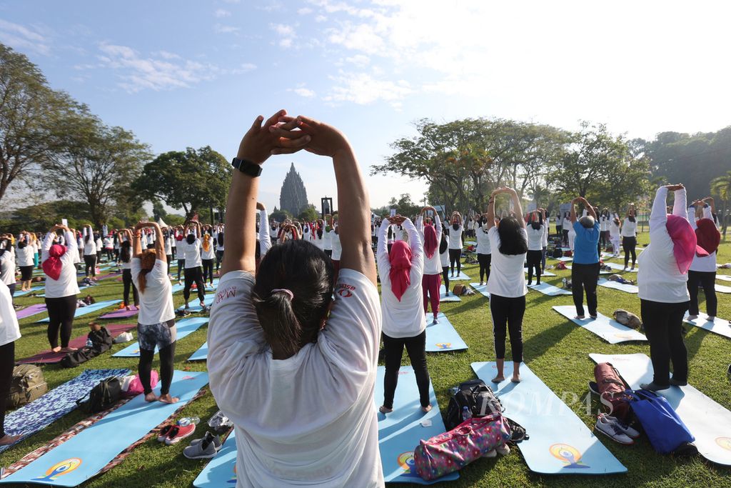 Peserta melakukan gerakan yoga saat mengikuti peringatan Hari Yoga Internasional di kompleks Taman Wisata Candi Prambanan, Sleman, DI Yogyakarta, Selasa (21/6/2022). Yoga dapat menjadi pilihan olahraga masyarakat di tengah puasa Ramadhan.