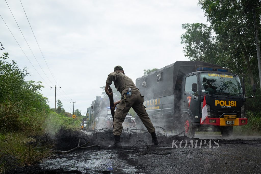 Petugas membersihkan pohon yang ditumbangkan dan dibakar warga untuk menghalangi aparat gabungan masuk ke Pulau Rempang, Batam, Kepulauan Riau, Kamis (7/9/2023).