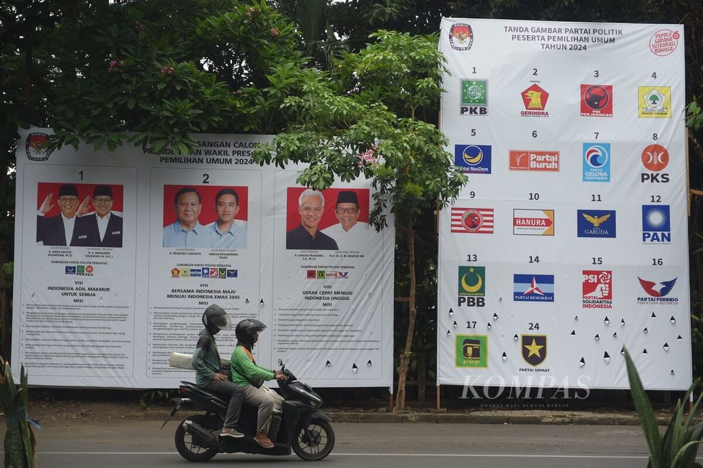 Warga melewati baliho resmi KPU yang memuat visi dan misi pasangan calon presiden dan calon wakil presiden Pemilihan Umum 2024 di Jalan Kayoon, Surabaya, Minggu (17/12/2023). 
