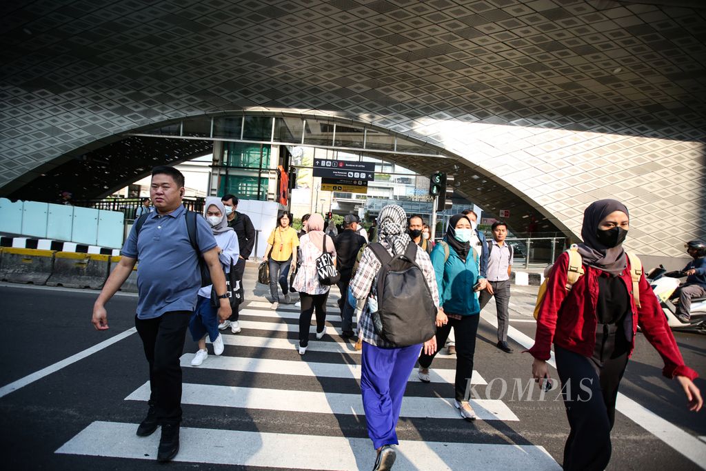 Para pejalan kaki yang didominasi karyawan menyeberang jalan dari halte Transjakarta di kawasan Bundaran Hotel Indonesia, Jakarta Pusat, Jumat (9/8/2024) pagi. Indonesia sempat mengalami ledakan penduduk kelas menengah pada periode 2014-2018. Saat itu, kelas menengah meningkat signifikan dari 39 juta jiwa atau 15,6 persen dari total populasi pada 2014 menjadi 60 juta orang atau 23 persen dari total populasi pada 2018.