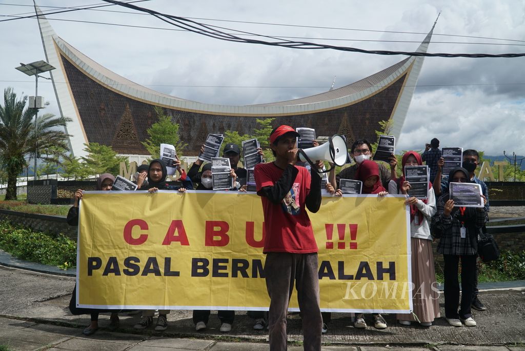 Koordinator lapangan aksi berorasi dalam unjuk rasa yang digelar anggota Aliansi Jurnalis Independen (AJI) Padang dan perwakilan lembaga pers mahasiswa di Kota Padang, Sumatera Barat, Senin (5/12/2022), untuk menuntut pencabutan 17 pasal bermasalah dalam rancangan KUHP. 