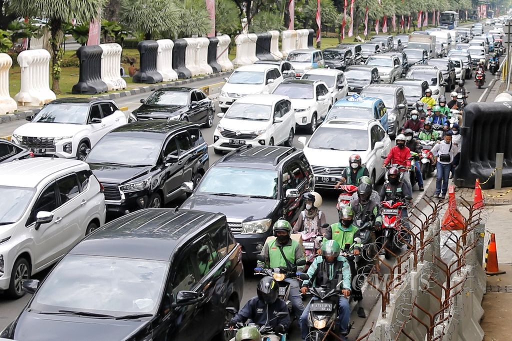 Warga terpaksa harus turun dan berjalan di badan Jalan Medan Merdeka Barat, Jakarta, karena trotoar dipenuhi oleh barrier demo, Kamis (3/11/2022). Hal tersebut membahayakan keselamatan pejalan kaki dari sambaran kendaraan bermotor di tengah lalu lintas yang sibuk.