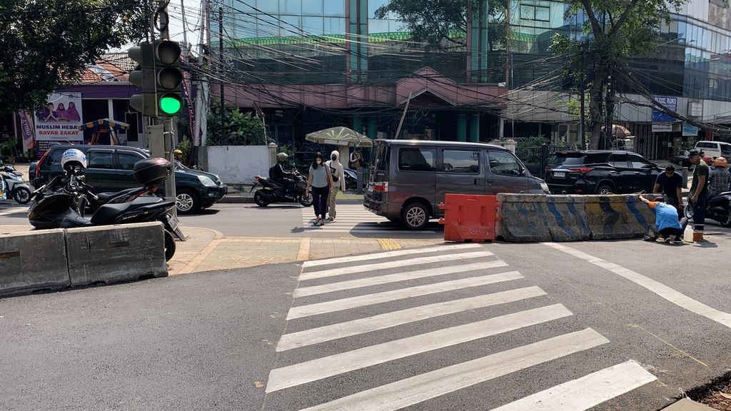 Sejumlah pejalan kaki melewati penyeberangan di jalan yang sebelumnya merupakan jalur pedestrian dan jalur sepeda di simpang Santa, Kebayoran Baru, Jakarta Selatan, Selasa (18/4/2023).