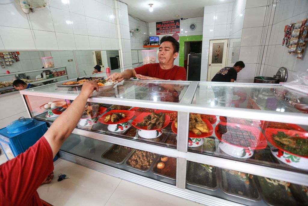 Pelayan melayani pelanggan di warung Tegal atau dikenal dengan warteg Mamoka Bahari di kawasan Pesanggrahan, Jakarta Selatan, Kamis (28/7/2022).