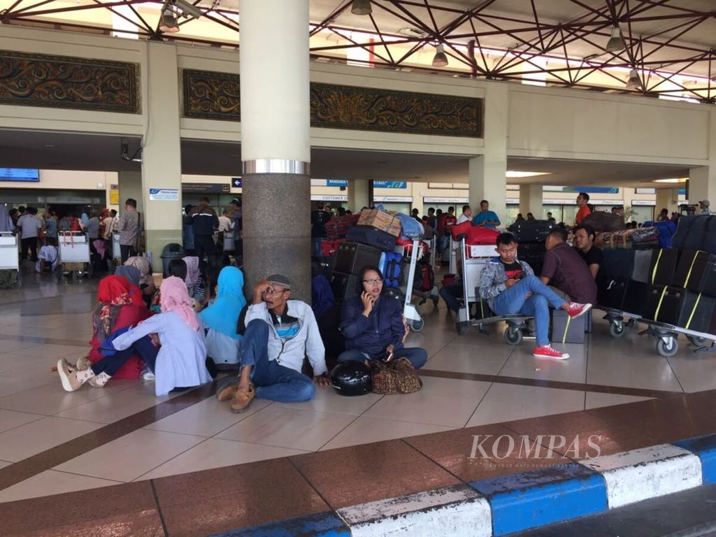 Penumpang duduk lesehan di lantai Terminal 1 Bandara Juanda menunggu kepastian jadwal penerbangan, Jumat (29/6/2018). 