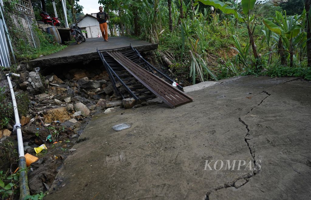 Rekahan jalan beton gang di Kampung Curug, Desa Bojong Koneng, Kecamatan Babakan Madang, Kabupaten Bogor, Jawa Barat, yang rusak berat akibat tanah bergerak, Rabu (21/9/2022). 