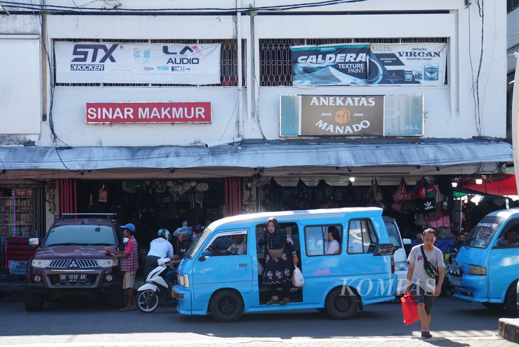 Penumpang turun dari mikrolet yang lewat di salah satu sisi pertokoan di Pasar 45, Manado, Sulawesi Utara, Senin (15/5/2023).