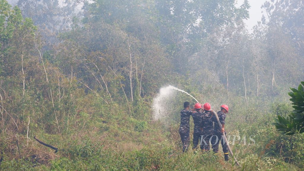 Petugas dari TNI Angkatan Laut berjuang untuk memadamkan kebakaran lahan gambut di Kelurahan Syamsudin Noor, Kecamatan Landasan Ulin, Kota Banjarbaru, Kalimantan Selatan, Sabtu (7/10/2023). 