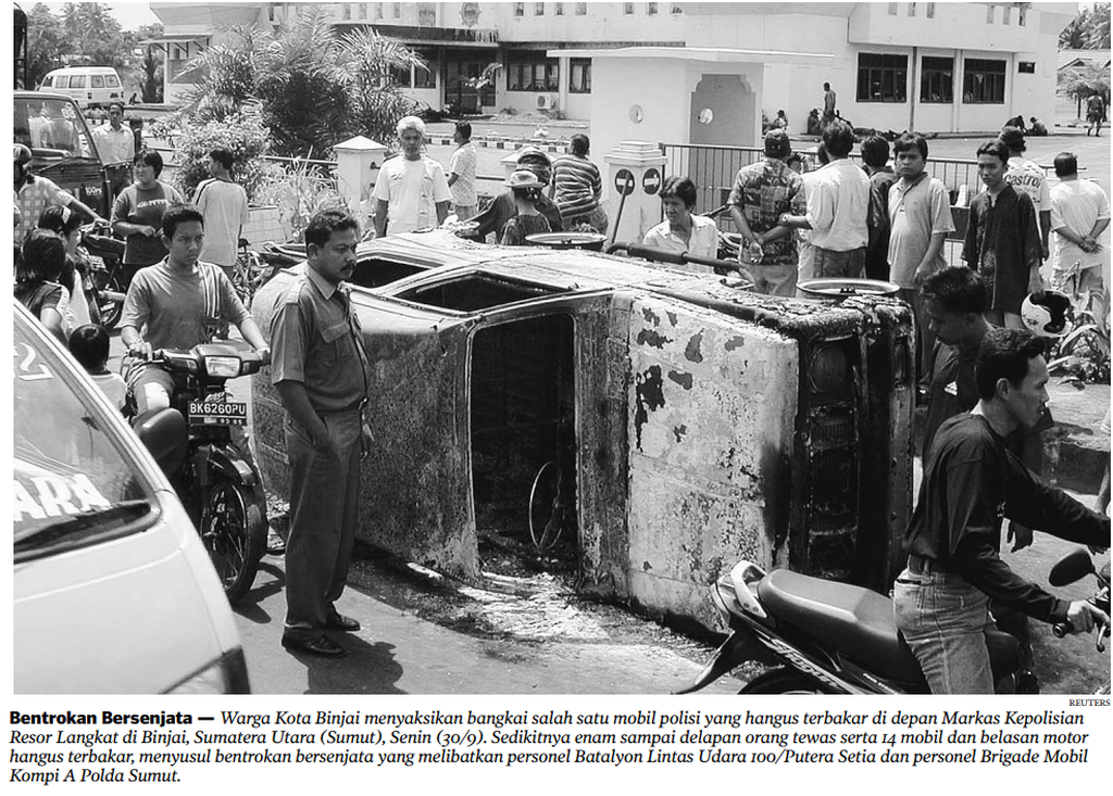 Warga Kota Binjai menyaksikan salah satu bangkai mobil polisi yang hangus terbakar di depan Markas Kepolisian Resor Langkat di Kota Binjai, Sumatera Utara, Senin (30/9/2002).