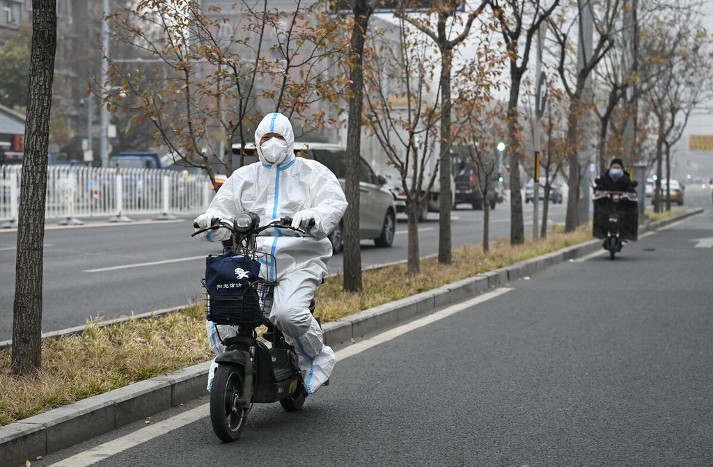  Warga yang memakai alat pelindung diri (APD) mengendarai skuternya di salah satu jalan di Beijing, China, Kamis (24/11/2022). 