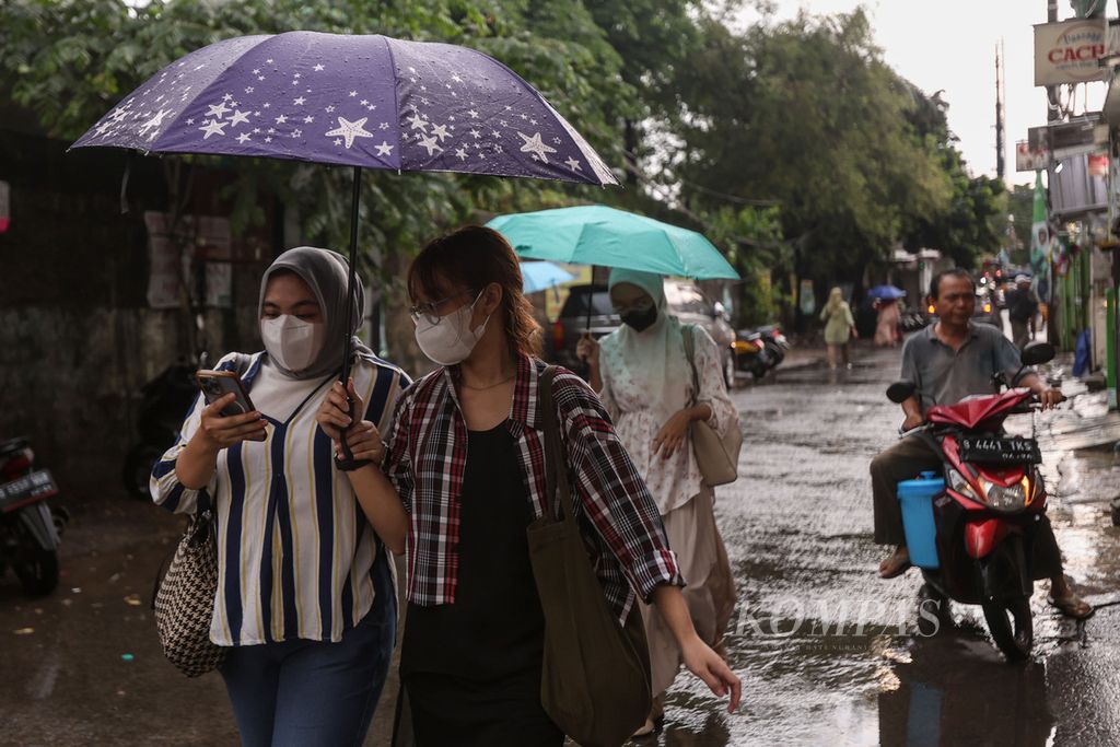 Warga mengenakan payung saat berjalan di Jalan Margonda, Kota Depok, Jawa Barat, Sabtu (13/1/2024). Hujan deras disertai petir mengguyur Kota Depok pada Sabtu sore. Kilat yang menyambar-nyambar membuat sejumlah warga memilih berteduh di sejumlah pertokoan. 