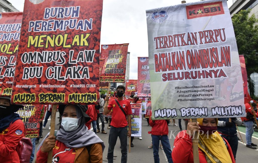 Poster bertuliskan penolakan atas UU Cipta Kerja dibawa massa buruh saat melakukan aksi bersama menolak UU CIpta Kerja di Jakarta, Kamis (22/10/2020). Pasca pengesahan RUU CIpta Kerja oleh DPR pada awal Oktober 2020, gelombang aksi penolakan terus disuarakan oleh para buruh dan elemen masyarakat di Jakarta dan sejumlah daerah lain di Indonesia. 