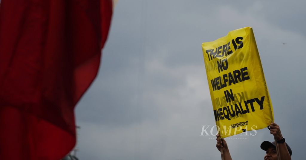 Aktivis Greenpeace mengangkat spanduknya saat bersama para buruh perempuan Konggres Aliansi Serikat Buruh Indonesia, Aliansi Jurnalis Independen Jakarta, dan sejumlah elemen masyarakat lainnya menggelar aksi peringatan Hari Perempuan Internasional di kawasan Patung Arjuna Wijaya, Jakarta, Jumat (8/3/2024). 