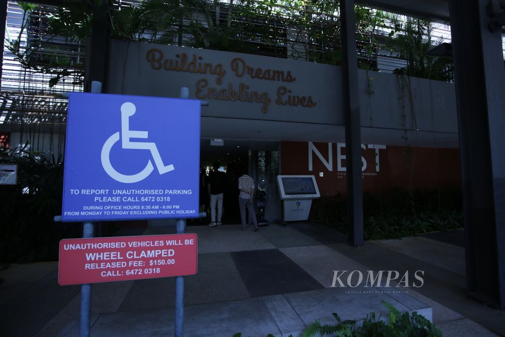 Pengunjung memasuki lobi Enabling Village di Lengkok Bahru, Singapura, Selasa (4/7/2023). Kompleks gedung ini menyediakan lapangan parkir khusus bagi penyandang disabilitas. 
